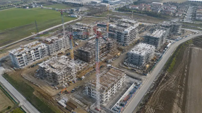 Vista aerea di un cantiere edilizio per la realizzazione di nuove abitazioni nell'ambito del Piano casa 2026, con gru e mezzi | SOAsemplice